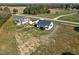 Aerial view of a modern farmhouse-style home with white siding, screened porch, detached garage, and long driveway at 1886 Mays Crossroad Rd, Louisburg, NC 27549