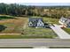 Aerial view of a modern farmhouse-style home with long driveway, large lawn, and road frontage at 1886 Mays Crossroad Rd, Louisburg, NC 27549