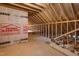 Unfinished attic with exposed framing, HomeGuard housewrap and Goldsboro Builder Supply advertisement at 1886 Mays Crossroad Rd, Louisburg, NC 27549