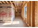 Unfinished attic room with stud framing, HomeGuard housewrap, and natural light from the window at 1886 Mays Crossroad Rd, Louisburg, NC 27549