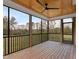 Relaxing screened-in porch with wood ceiling, black railings, ceiling fan, and view of the backyard at 1886 Mays Crossroad Rd, Louisburg, NC 27549