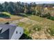 Aerial view of the property showcasing a large backyard, landscaping, and white farmhouse at 1886 Mays Crossroad Rd, Louisburg, NC 27549