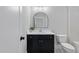 Modern bathroom featuring a sleek vanity with a black cabinet and an elegant, rounded mirror at 1886 Mays Crossroad Rd, Louisburg, NC 27549
