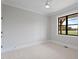 Bright bedroom with ceiling fan and view of backyard through window at 1886 Mays Crossroad Rd, Louisburg, NC 27549