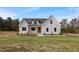 Charming white farmhouse with black trim, stone accents, and a well-manicured lawn, under a sunny blue sky at 1886 Mays Crossroad Rd, Louisburg, NC 27549