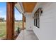 Inviting front porch with stone flooring, wood columns, and stylish front door at 1886 Mays Crossroad Rd, Louisburg, NC 27549