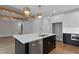 Spacious, open-concept kitchen with stainless steel appliances, a black island, and abundant natural light at 1886 Mays Crossroad Rd, Louisburg, NC 27549