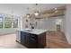 Well lit kitchen with stainless steel dishwasher and sink, a black island, and natural wood beams at 1886 Mays Crossroad Rd, Louisburg, NC 27549