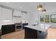 Modern kitchen with white cabinets, black island, stainless steel appliances and stylish pendant lighting at 1886 Mays Crossroad Rd, Louisburg, NC 27549