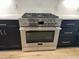 New stainless gas range and oven in kitchen with black cabinets and hardware and white countertop at 1886 Mays Crossroad Rd, Louisburg, NC 27549
