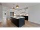 Bright kitchen featuring a black island, stainless steel appliances, and modern pendant lights at 1886 Mays Crossroad Rd, Louisburg, NC 27549