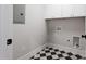Bright laundry room featuring black and white tiled flooring and ample storage with overhead cabinets at 1886 Mays Crossroad Rd, Louisburg, NC 27549