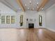 Cozy living area showcasing wood floors, fireplace, beamed ceiling and french doors to porch at 1886 Mays Crossroad Rd, Louisburg, NC 27549