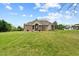 Expansive backyard with lush green lawn, a covered patio, and views of the surrounding landscape at 2011 Gibsonville Ossipee Rd, Elon, NC 27244
