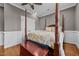 Bedroom featuring a four-poster bed, hardwood floors, and painted wood trim at 2011 Gibsonville Ossipee Rd, Elon, NC 27244