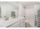 Bright bathroom featuring a double vanity, framed mirror, and shower-tub combo with white fixtures at 2013 Magnolia Tree Ln, Durham, NC 27703