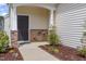 Charming front porch with stone accents, a black door, and manicured landscaping, creating a welcoming entrance at 2013 Magnolia Tree Ln, Durham, NC 27703