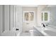 Modern bathroom features double sinks, marble counters, a window for natural light, and a tub/shower combo at 206 Rocky Hills Rd, Pittsboro, NC 27312