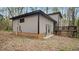Rear exterior view of home with a wooden deck, back yard, and wooded surroundings at 206 Rocky Hills Rd, Pittsboro, NC 27312