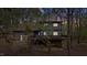 Exterior view of a two-story gray home with a deck and a wooded lot at 206 Rocky Hills Rd, Pittsboro, NC 27312