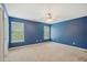 This bedroom features cool-toned walls and ample natural light from dual windows at 2223 Lazy River Dr, Raleigh, NC 27610