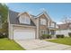 Charming two-story home featuring a stone facade, a two-car garage, and a well-maintained front yard at 2223 Lazy River Dr, Raleigh, NC 27610
