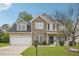 Charming two-story home featuring a stone facade, attached garage, and well-manicured lawn at 2223 Lazy River Dr, Raleigh, NC 27610