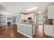 Open concept kitchen overlooking the living area, featuring white cabinets and a breakfast bar at 2223 Lazy River Dr, Raleigh, NC 27610