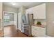 Kitchen area featuring stainless steel refrigerator, white cabinets and view into the dining area at 2223 Lazy River Dr, Raleigh, NC 27610