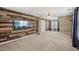 Spacious living room with a rustic wood accent wall, a ceiling fan, and natural light at 2223 Lazy River Dr, Raleigh, NC 27610
