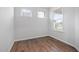 Bedroom with hardwood floors, two windows, and white walls at 2304 Beeblossom Pl, Fuquay Varina, NC 27526