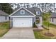 Charming home showcasing a gray exterior, white trim, and a two-car garage at 2304 Beeblossom Pl, Fuquay Varina, NC 27526