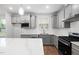 Modern kitchen featuring gray cabinets, stainless steel appliances, island and white countertops at 2304 Beeblossom Pl, Fuquay Varina, NC 27526