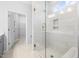 Luxurious walk-in shower showcasing elegant tilework, glass door, built-in niche, and a convenient bench at 2316 Beeblossom Pl, Fuquay Varina, NC 27526