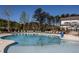 Relaxing community pool with lounge chairs, umbrellas, and surrounding trees offers a tranquil outdoor experience at 2316 Beeblossom Pl, Fuquay Varina, NC 27526