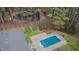 Aerial view of property showing home, pool, and tranquil pond surrounded by lush trees at 2411 Lynch Store Rd, Mebane, NC 27302