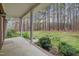 Covered back porch overlooking a lush backyard with mature trees, offering a peaceful outdoor retreat at 2411 Lynch Store Rd, Mebane, NC 27302