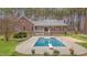Backyard view of a brick home with pool, diving board, and landscaped yard, ideal for outdoor living at 2411 Lynch Store Rd, Mebane, NC 27302