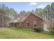 Lovely brick home with manicured landscaping, mature trees, and an attached garage creating a serene setting at 2411 Lynch Store Rd, Mebane, NC 27302
