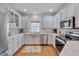 This kitchen is equipped with stainless steel appliances, light-colored cabinets and granite countertops at 2411 Lynch Store Rd, Mebane, NC 27302