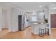 Bright kitchen features stainless steel appliances, light-colored cabinetry, hardwood floors and a kitchen island with seating at 2411 Lynch Store Rd, Mebane, NC 27302