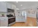 Modern kitchen with stainless steel appliances, light countertops and an island with storage at 2411 Lynch Store Rd, Mebane, NC 27302