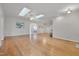 Spacious living room with hardwood floors, skylights, and neutral paint, perfect for comfortable living and entertaining at 2411 Lynch Store Rd, Mebane, NC 27302
