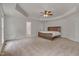 Spacious main bedroom featuring a tray ceiling, a ceiling fan, neutral carpet and a private ensuite bathroom at 2411 Lynch Store Rd, Mebane, NC 27302