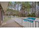View of a backyard pool with a deck and white railings surrounded by tall trees, offering a serene outdoor space at 2411 Lynch Store Rd, Mebane, NC 27302
