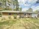 Exterior view of backyard featuring a brick house, lawn, patio, and mature trees at 2501 Landis Dr, Durham, NC 27705