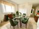 Bright dining area with glass table, stylish green chairs, and storage cabinets at 2501 Landis Dr, Durham, NC 27705