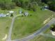 This aerial view reveals a spacious layout with the home surrounded by lush greenery and an adjacent road at 2651 Bennett Rd, Creedmoor, NC 27522