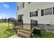 A wooden back deck with black railings leads to doors and windows on the two-story home at 2651 Bennett Rd, Creedmoor, NC 27522