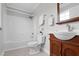Bathroom featuring white shower and bath, toilet, and cherry wood vanity with sink and cabinet at 2651 Bennett Rd, Creedmoor, NC 27522